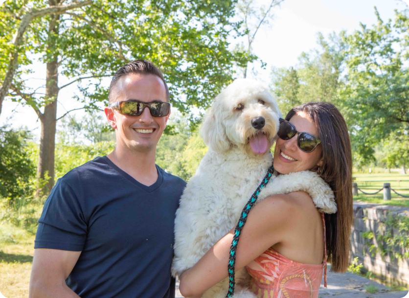 Man and woman holding their dog